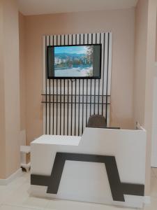 斯库台Hotel Restaurant Univers的一间设有白色桌子的房间和墙上的电视