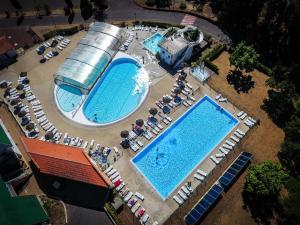 莱昂LES COTTAGES DE LEON的享有两个带桌椅的游泳池的顶部景致