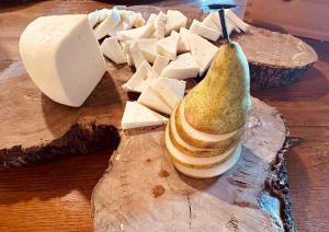 圣温琴佐Glamping San Bart的一块布满奶酪的切板和梨子