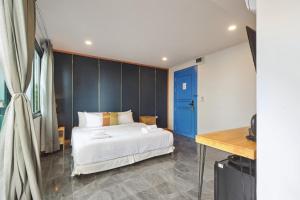 尖竹汶Ployburi Boutique Hotel的卧室配有白色的床和蓝色的墙壁