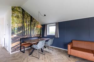 奥德米拉得姆Recreatiepark De Bosrand的一间带桌椅和沙发的用餐室