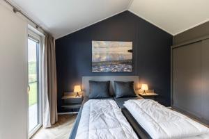 奥德米拉得姆Recreatiepark De Bosrand的一间卧室设有一张大床和黑色的墙壁