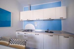 蒂勒尼亚Solidago Residence的厨房配有白色橱柜和水槽
