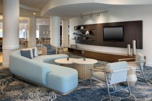 德斯坦盛大大道圣德斯廷万怡酒店的大堂配有沙发、电视和椅子。