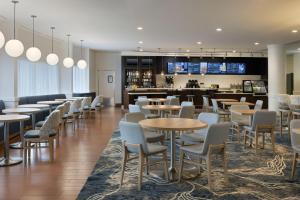 德斯坦盛大大道圣德斯廷万怡酒店的一间带桌椅的餐厅和一间酒吧