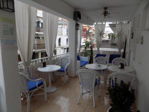 埃尔阿雷纳尔玛如织别墅酒店的餐厅设有白色的桌椅和窗户。