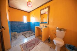 El GoueraAladdin Desert Camp的一间带卫生间、水槽和镜子的浴室