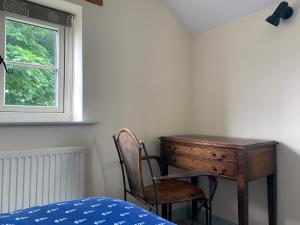 什鲁斯伯里Farmhouse studio near Shrewsbury的卧室配有书桌和靠窗的椅子