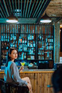 Ðá LònChay Lap Farmstay Phong Nha的坐在酒吧喝一杯的女人