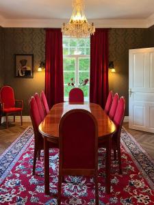 玛丽港Strandnäs Gård的一间带木桌和红色椅子的用餐室