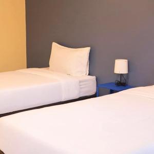 Ban Khao LaoIntha Resort的一张桌子上灯的房间里两张床铺
