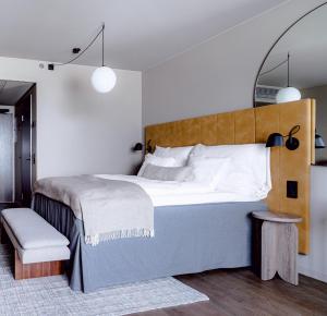 万塔Clarion Hotel Helsinki Airport的一间卧室配有一张大床和木制床头板