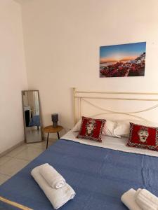 法维尼亚纳A Due Passi dal Centro的一间卧室配有一张带蓝色床单和红色枕头的床。