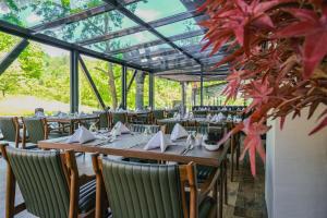 埃利特温泉Vital Thermal Hotel & SPA的一间用餐室,配有桌椅和红色的叶子