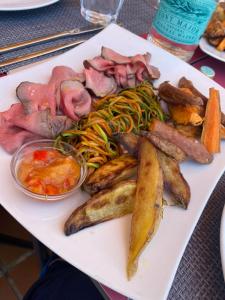 卡兰博希Nuramar Resort & Villas的桌上一盘带肉和蔬菜的食物