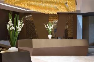 麦纳麦Hilton Bahrain的大堂设有鲜花和吊灯的前台