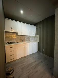 阿塔库姆deperlas的厨房铺有木地板,配有白色橱柜。