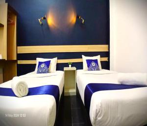 Kota BharuAlia Express Green Mango, Kota Bharu的一间设有两张蓝色和白色床铺的客房