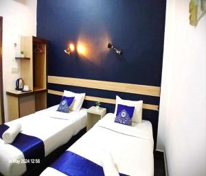 Kota BharuAlia Express Green Mango, Kota Bharu的蓝色和白色的客房内的两张床