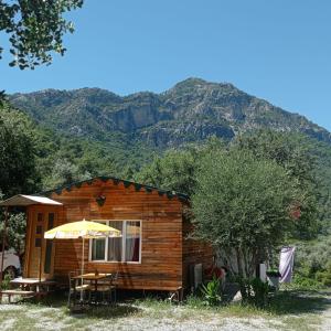 穆拉Eses Camping bungalov的小木屋,后方是一座山