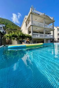 比耶拉Family House with pool & sea view的大楼前带冲浪板的游泳池