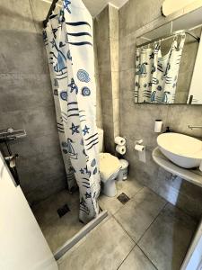 Megali AmmosAnna的一间带卫生间、水槽和镜子的浴室