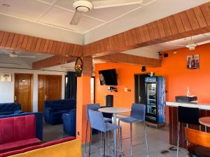 瓦加杜古AG HOTEL Ouaga的客房拥有橙色的墙壁和桌椅。