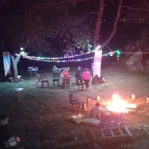 穆拉Eses Camping bungalov的一群人晚上站在 ⁇ 火旁