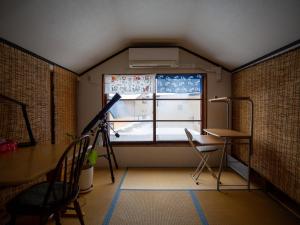 YakumoKominka Guesthouse SENTŌ的客房设有窗户、书桌和桌子。