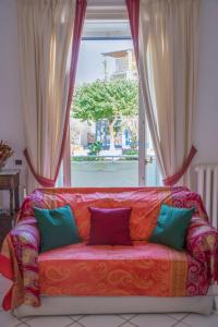 阿纳卡普里House via Orlandi for 5 people的靠窗前的沙发,配有枕头