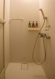 YakumoKominka Guesthouse SENTŌ的浴室里设有淋浴,架子上装有两瓶