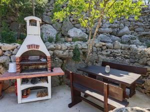 亚布拉纳茨House Kaja的坐在野餐桌和长凳旁的烧烤架