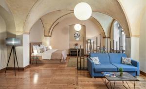 布拉格3 Epoques Apartments by Adrez的客厅配有蓝色的沙发和床。