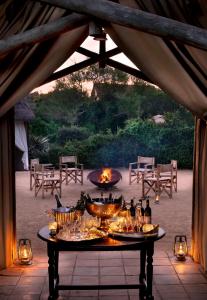 阿多戈拉大象营酒店的露台上的桌子上摆放着食物和饮料