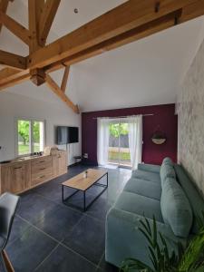 Maisons au cœur du berry的客厅配有绿色沙发和桌子