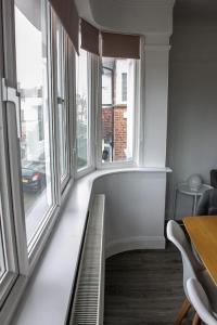 滨海绍森德Stylish Retreat in Leigh-on-Sea的客房设有大窗户和桌椅。