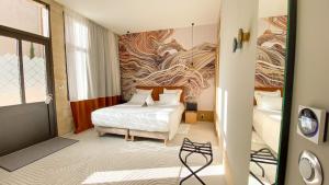 拉蒙塔涅AUX DUCS DE SIENNE的酒店客房设有一张床,墙上挂有绘画作品