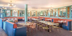 穆林加尔Bloomfield House Hotel, Leisure Club & Spa的一间在房间内配有桌椅的餐厅