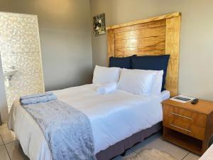 谢普斯敦港La Vue的卧室配有一张白色大床和木制床头板