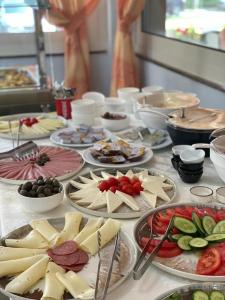 都拉斯Hotel Vila Misiri的餐桌上放有奶酪和其他食物的盘子