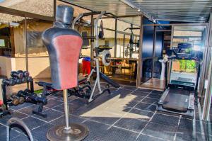 哈拉雷Riverstone Guest Lodge的一间设有健身房、椅子和举重设施的客房