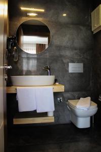 居吕克Gulluk Life Hotel的一间带水槽、卫生间和镜子的浴室