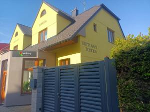 特热邦Ubytování Pohoda的前面有栅栏的黄色房子