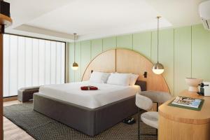 麦德林Wellcomm Spa & Hotel的配有一张床和一把椅子的酒店客房