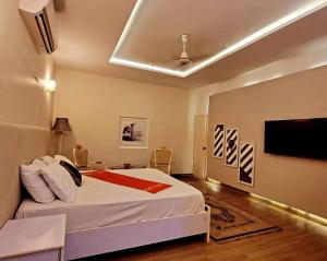 卡拉奇Heavenly Stays的卧室配有一张床,墙上配有电视。