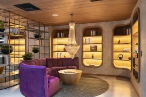 麦德林Wellcomm Spa & Hotel的客厅配有紫色沙发和桌子