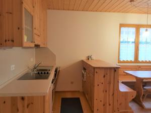 巴德小基希海姆Haus Renata by Globalimmoservice的厨房配有木制橱柜、水槽和桌子