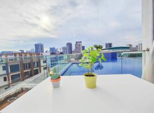 新加坡Centralize Stylish Loft Apartment Beside Mrt 摩登小屋的大楼顶部的白色桌子和植物