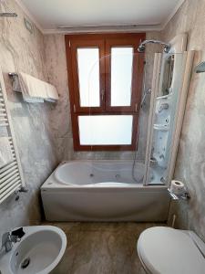 威尼斯佛斯卡里宫殿酒店的带浴缸、卫生间和盥洗盆的浴室