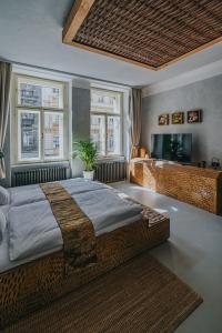 布拉格Art hotel Sazavska的一间卧室设有一张大床和两个窗户。